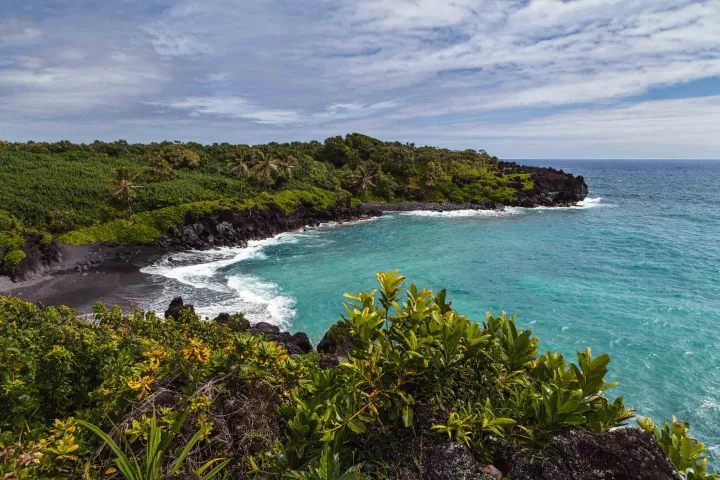 Black Sand Beach turquoise ocean lush vegetation Waianapanapa State Park