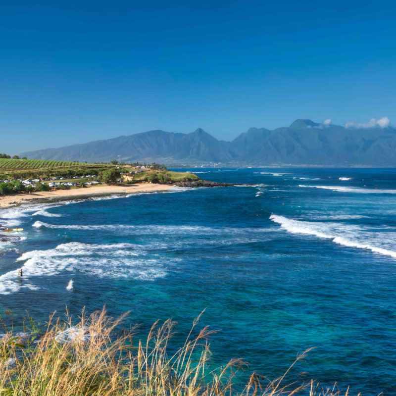 a body of water with a mountain in the ocean